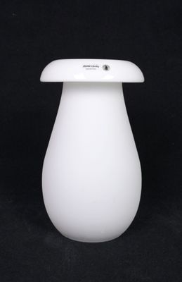 a white vase with a white lid on a black background