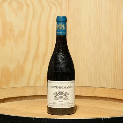 a bottle of wine sitting on top of a barrel