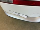 a white car with a sticker on it ' s bumper