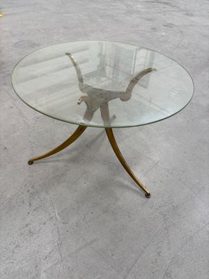 une photo d'une table en verre avec des pieds dorés et un plateau en verre