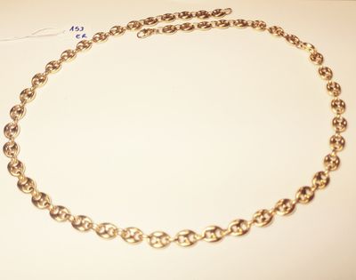 a close up of a gold chain necklace on a white surface