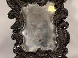 un miroir ancien plaqué argent, orné d'un motif décoratif sur le pourtour