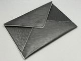 un gros plan d'une enveloppe noire posée sur une surface blanche