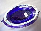 a blue glass bowl with a silver rim on a table