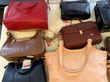 a lot of purses sitting on a table together