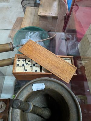a wooden box with dice pieces in it on a glass table