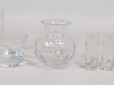 four glass vases and two glasses sitting on a table