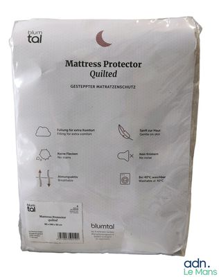 le protège-matelas se trouve dans son emballage, sur fond blanc