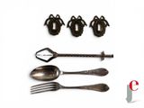 four spoons, a fork, and a knife on a white surface