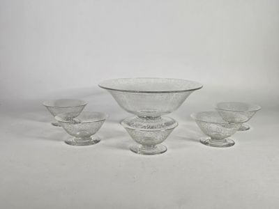 quatre bols en verre transparent et un bol posé sur une surface blanche