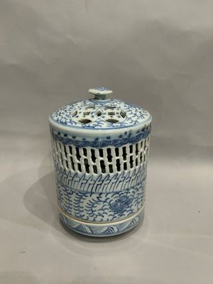a blue and white jar with a lid on a table