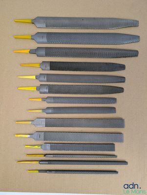 Plusieurs types d'outils sont alignés sur une surface marron