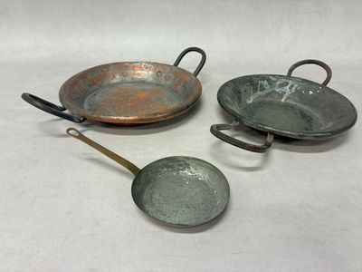 trois types différents de casseroles et poêles posés sur un plan de travail blanc