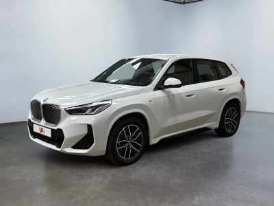 a white bmw x5 parked in a white room