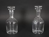 pair of clear glass bottles on a black background