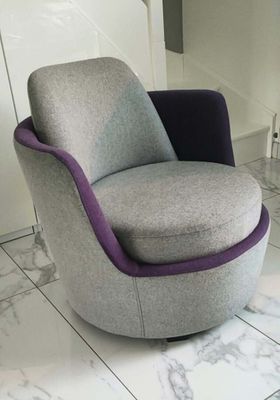 une chaise grise et violette posée sur un sol carrelé blanc