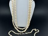 un ensemble composé d'un collier et d'un bracelet en perles blanches, présenté sur un présentoir pour mannequin