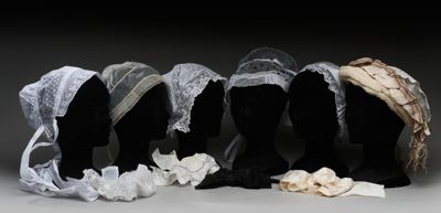 six têtes de mannequins sont alignées en rang, coiffées de chapeaux