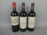 three bottles of wine are lined up on a gray surface