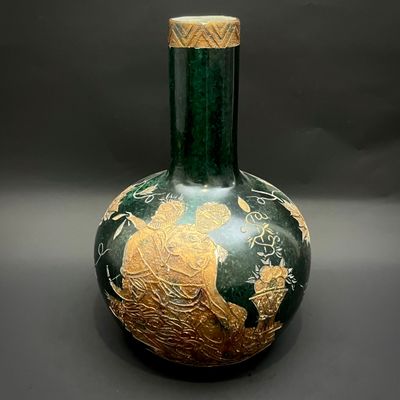 un vase vert orné d'un motif doré