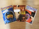 three comic books sitting on top of a wooden table next to each other