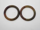 deux bracelets marron et verts posés sur une surface blanche