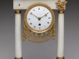 une horloge blanche et or posée sur une table
