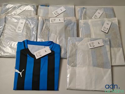 un lot de maillots de foot bleus et noirs posés sur une table