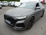 un SUV Audi gris garé sur un parking à côté d'autres voitures