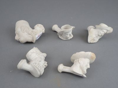 six figurines blanches de formes et de tailles différentes posées sur une surface grise
