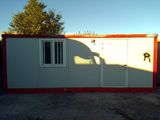 a white and red building with a red door and window