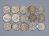 six different types of coins are arranged in a row on a white surface