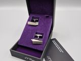 une paire de boutons de manchette dans un coffret cadeau doublé de velours violet