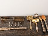 beaucoup d'argenterie sur une table avec des cuillères et des couteaux