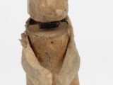une sculpture en bois représentant un lapin assis sur ses pattes arrière