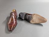pair of brown shoes sitting on top of a table next to each other