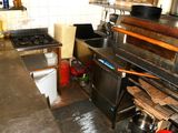 a kitchen with a stove, oven, sink, and other items in it