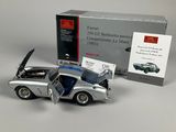 a silver toy car with open doors and a box in the background
