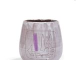 un vase violet orné d'un motif sur un fond blanc