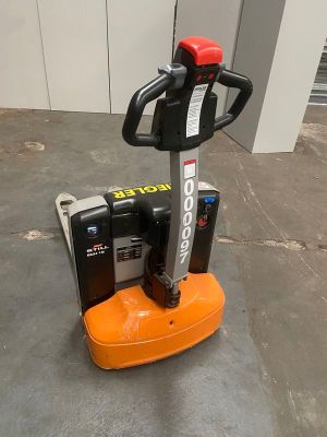 un chariot élévateur électrique orange et noir posé sur un sol en béton