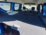 the interior of a blue van with the back door open