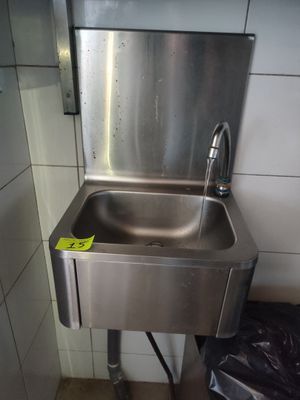un évier en acier inoxydable dans le coin d'une salle de bains