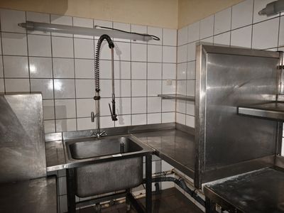 une cuisine équipée d'un évier, d'une cuisinière et d'un robinet