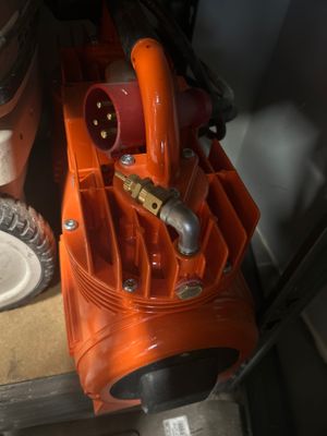 un souffleur orange posé par terre à côté d'une assiette blanche