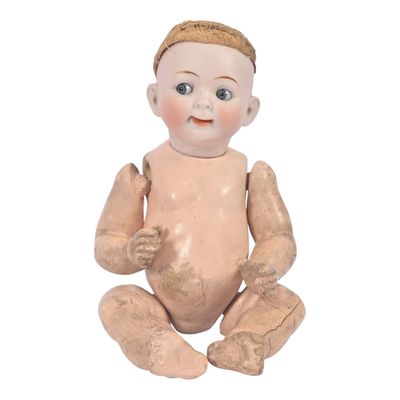 a small doll sitting on the ground with a hat on