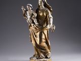 an antique bronze statue of a woman holding a child