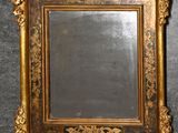 un miroir ancien dans un cadre doré, accroché à un mur sur fond noir