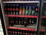 Des bouteilles de soda et de boissons non alcoolisées sont exposées dans un réfrigérateur