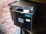 a small refrigerator sitting on a shelf in the corner of a room