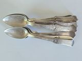 three spoons that are sitting on a table